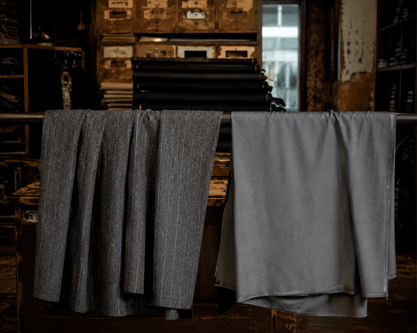 Two suit cloths hanging to compare drape and weight